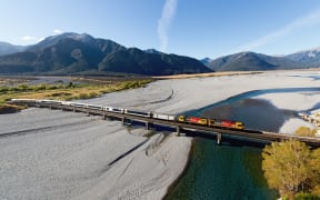 The TranzAlpine train crosses the Waimakariri bridge.