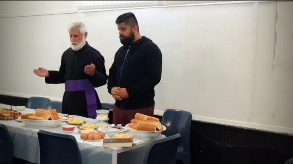 Father Aprem Pithyou blessing the Sunday breakfast