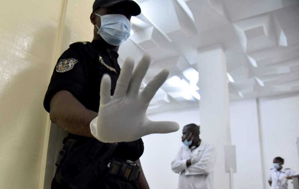 Police and medical staff at an Ivory Coast airport waiting for passengers flying in from Guinea.