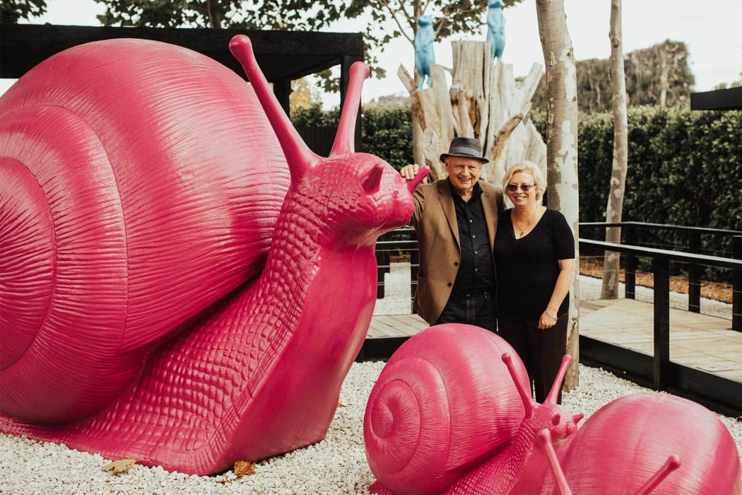 Sculptureum owner Anthony Grant with Pink Snails by the Cracking Art Group