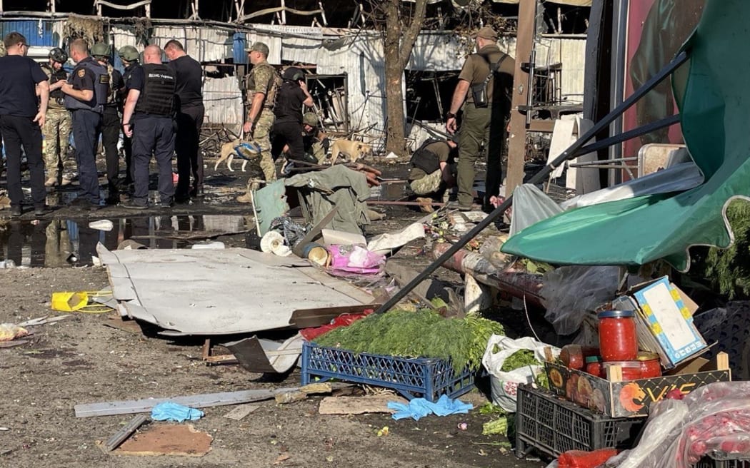 Ukrainian servicemen and rescuers stand near wreckages following a Russian strike in Kostyantynivka, Ukraine's eastern Donetsk region on September 6, 2023, amid the Russian invasion of Ukraine. Ukrainian President said a Russian strike on a market in east Ukraine had killed more than a dozen people and wounded more, as US Secretary of State was visiting Kyiv. (Photo by STRINGER / AFP)