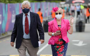 A couple arrive at Cup Day at Addington when numbers hugely restricted cos of Covid