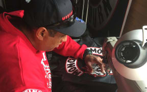 Man in cap at sewing machine