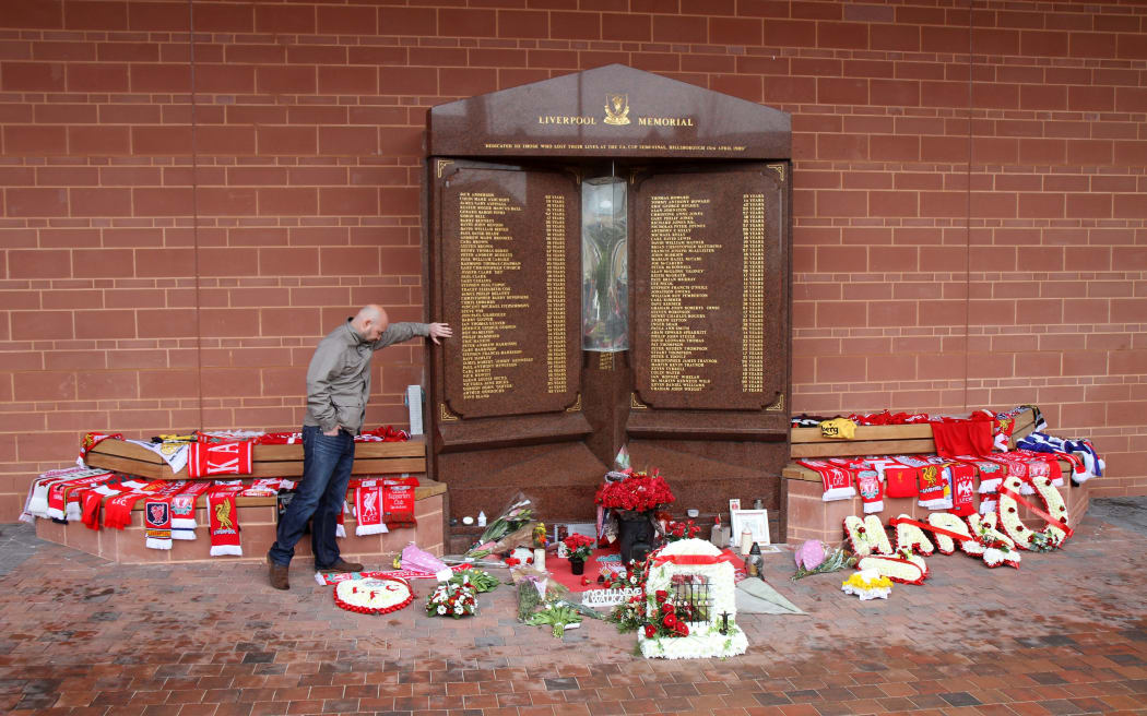 A fan pays his respects at the Hillsborough memorial outside the Anfield stadium