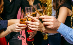 Many young women and men drinking at christmas party on white studio background