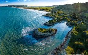 Mahanga Beach and Pukenui Beach, with isthmus separating Mahia Peninsula at far left. Happy Jacks Boat Harbour right. Aerial view. Mahanga Beach, Wairoa District. North Island, NZ.