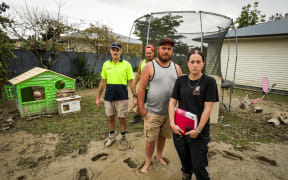 people stand in mud in front a of a trampoline