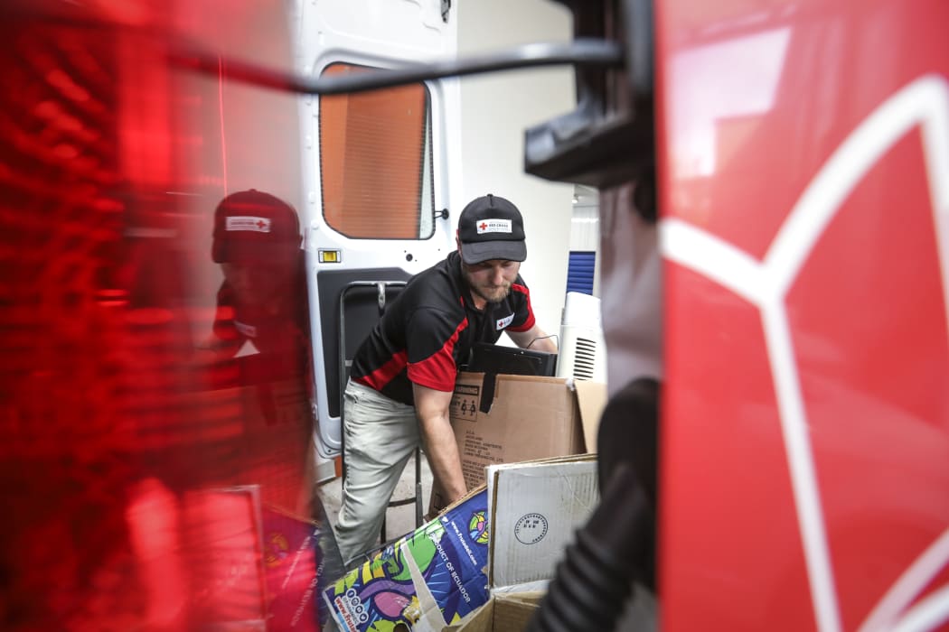 David Crisp, a Red Cross driver loading rubbish into a van heading for the tip.