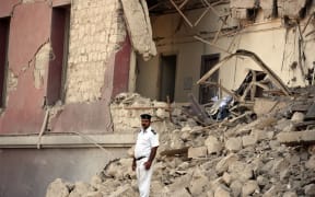 Egyptian policeman in the rubble of the Italian consulate in Cairo.