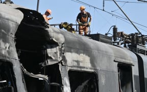Employees repair a power supply line over an Intercity+ high-speed train heavily damaged in a depot during a large-scale Russian drone and missile attack on Kyiv, on 28 August, 2025.