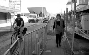 A black and white image of people walking on a Christchurch Road