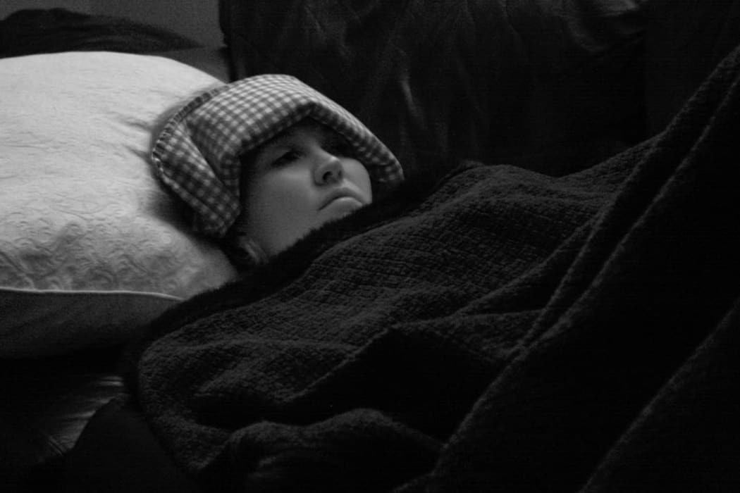 Migraine sufferer in a darkened room