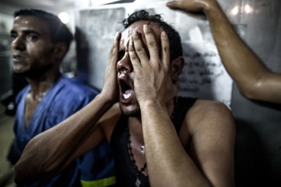A relative reacts after seeing the bodies of children killed in an explosion in a playground in Gaza in late July.