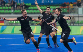New Zealand's Shea McAleese, (right) celebrates scoring against Germany at the Rio Olympics along with Nick Wilson (left)  and Kane Russell (centre).