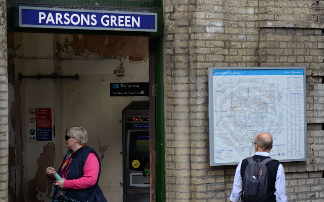 Commuters walk outside Parsons Green station, which was re-opened in the early hours of the morning following a bomb attack on a packed underground train, in south-west London on September 16, 2017.
