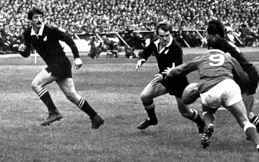 Doug Rollerson about to receive a pass from halfback Dave Loveridge against Wales in 1980.
All Blacks captain Graham Mourie looms outside Rollerson.