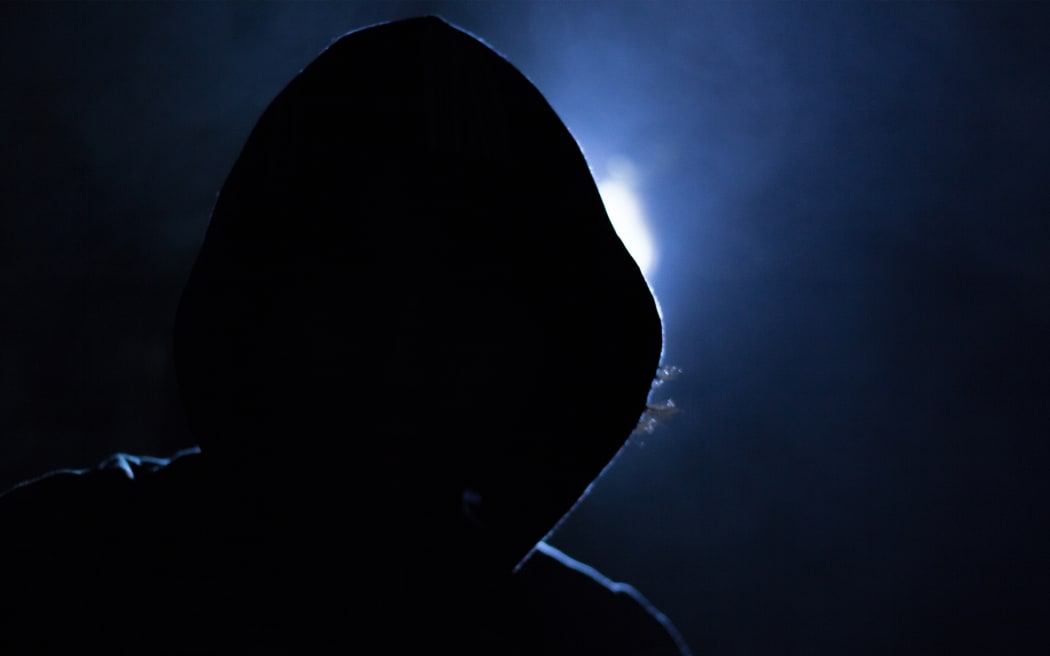 Hooded figure at night