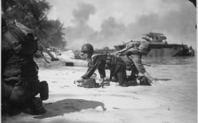 U.S. Marines crawl past each other under enemy fire during the Battle of Saipan.