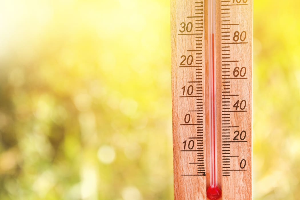 Thermometer displaying high 30 degree hot temperatures in sun summer day