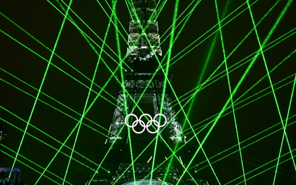 Lights illuminate the Eiffel Tower during the opening ceremony of the Paris 2024 Olympic Games in Paris on July 26, 2024. (Photo by Loic VENANCE / POOL / AFP)