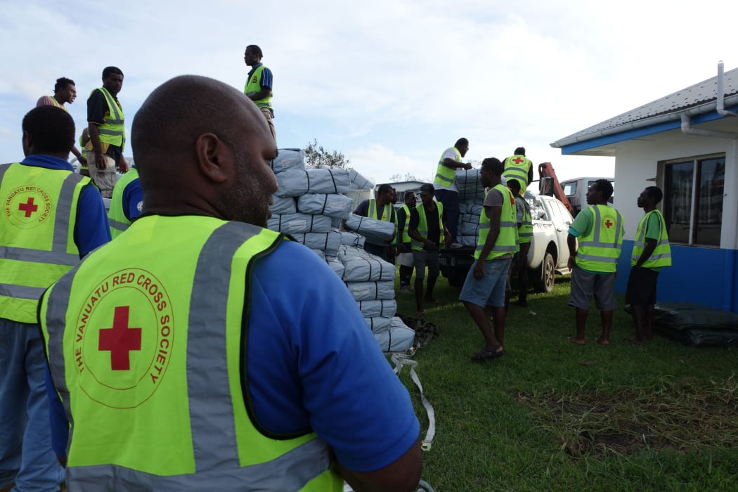 Vanuatu Red Cross workers load relief supplies brought in on a NZAF Hercules. Much needed tarpaulins, water containers and health and sanitation kits were being stored until further notice was given from the NDMO