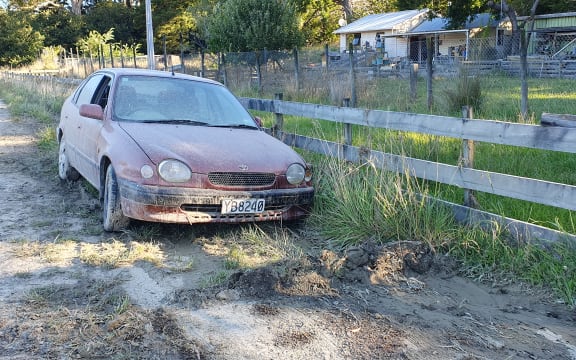 An abandoned mud covered car outside Tīnui shows how high the Whareama River got, near Wairarapa's east coast.