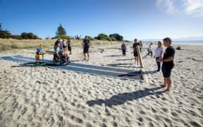 Caleb Harcus and his son, Ethan, trialled a new Mobi-Mat at Tāhunanui on Monday, a device that allows wheelchair users and those with strollers and walkers, who struggle to get over soft sand, to get closer to the water.