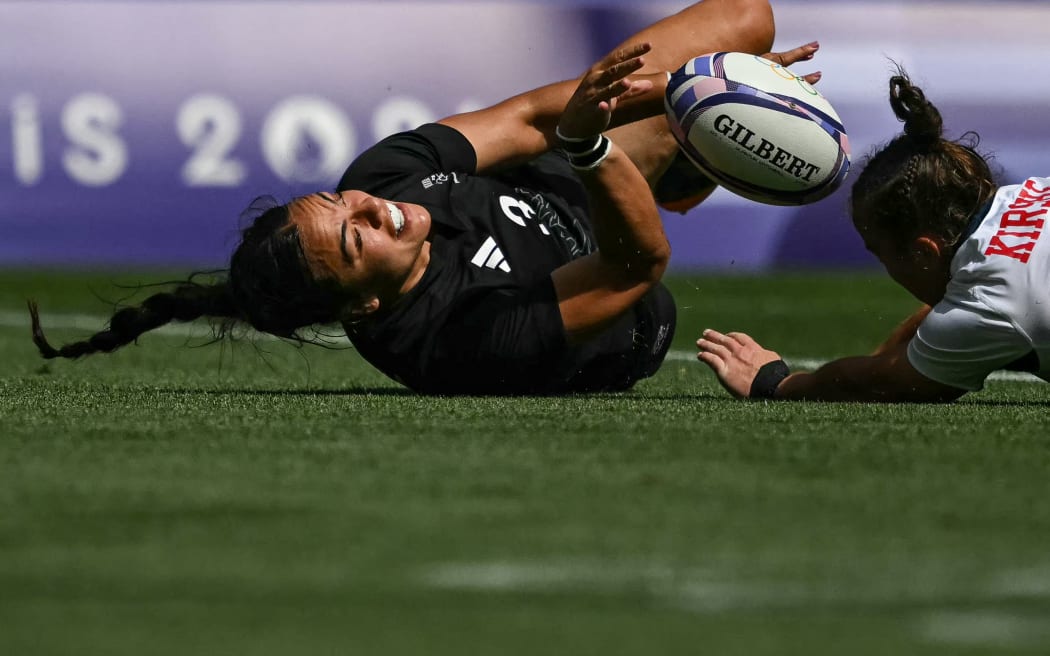 New Zealand's Stacey Waaka (L) scores a try as tackled by US' Kristi Kirshe (R) during the women's semi-final rugby sevens match between New Zealand and USA during the Paris 2024 Olympic Games at the Stade de France in Saint-Denis on July 30, 2024. (Photo by CARL DE SOUZA / AFP)