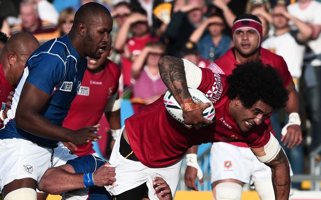 A photo of Hale T Pole running with the ball while playing for Tonga against England in the Rugby World Cup. The match was in Paris in September 2007.