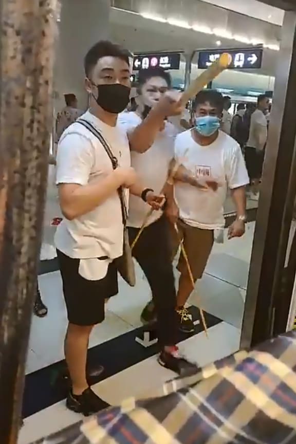 This frame grab taken from video recorded on July 21, 2019 shows a mob of men in white T-shirts threatening pro-democracy protesters (out of frame at R on train) at Yuen Long station in Hong Kong.
