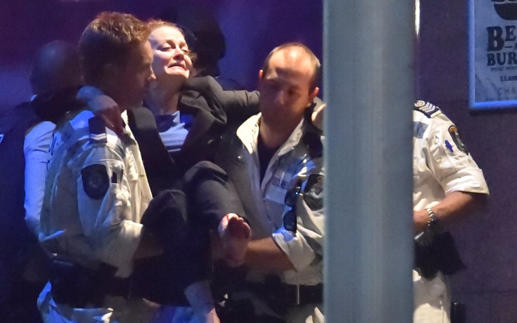 An injured hostage is carried out of a Sydney cafe at the centre of the hostage crisis.