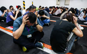 People take shelter during an air raid drill coinciding with the Han Kuang military exercises in Taipei on July 17, 2025. The annual civilian drill is being held in cities across Taiwan this week, alongside military training, to prepare the self-governed island for a potential Chinese invasion. (Photo by I-Hwa Cheng / AFP) / “The erroneous mention[s] appearing in the metadata of this photo by I-Hwa Cheng has been modified in AFP systems in the following manner: [Han Kuang military exercises] instead of [Kan Huang military exercises]. Please immediately remove the erroneous mention[s] from all your online services and delete it (them) from your servers. If you have been authorized by AFP to distribute it (them) to third parties, please ensure that the same actions are carried out by them. Failure to promptly comply with these instructions will entail liability on your part for any continued or post notification usage. Therefore we thank you very much for all your attention and prompt action. We are sorry...