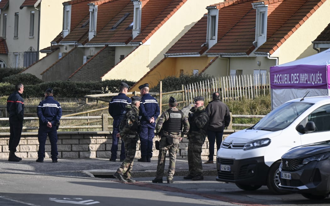 French gendarme and a member of the Civil Defence stand in front of a tent that receive migrants after a failed attempt to cross the English Channel that led to the death of 8 people near the beach of Ambleteuse, northern France on September 15, 2024. Eight migrants died when their clandestine boat sank off Ambleteuse (Pas-de-Calais) on September 15, 2024, bringing to over 45 the number of would-be exiles to Britain who died in the Channel in 2024. (Photo by Bernard BARRON / AFP)
