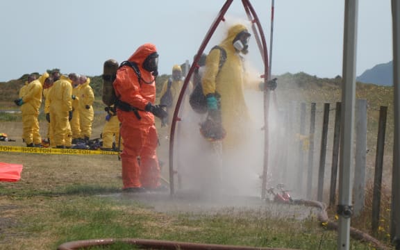 Recovery teams wash off toxic residues after their mission to Whakaari/White Island.