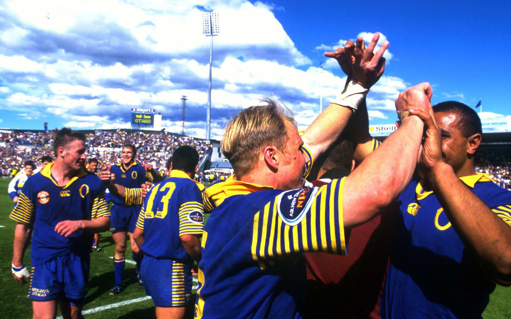 Jeff Wilson celebrates with the Otago team after winning the NPC Finals against Waikato 49-20 at Carisbrook, Dunedin, New Zealand. 25 October 1998. Photo: Andrew Cornaga/Photosport.co.nz