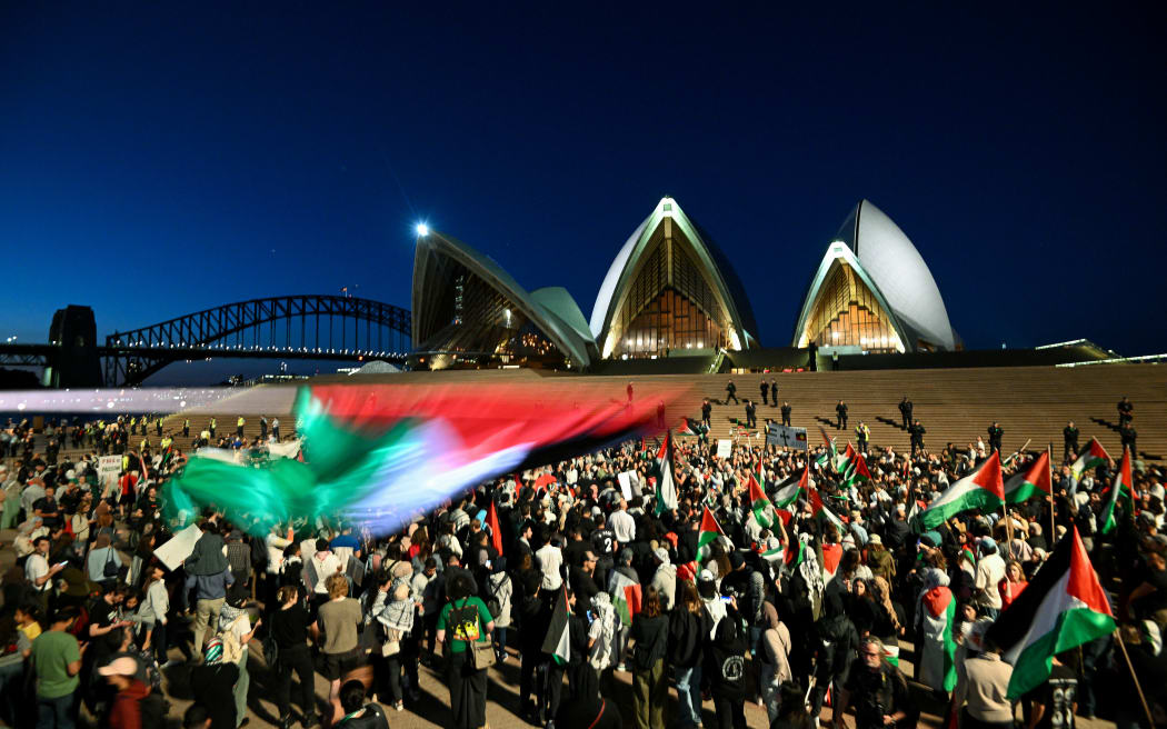 Protesters show their support for Palestinians during a rally in front of the Opera House in Sydney on October 9, 2023. Israel relentlessly pounded the Gaza Strip overnight and into October 9 as fighting with Hamas continued around the Gaza Strip, as the death toll from the war against the Palestinian militants surged above 1,100. (Photo by Izhar KHAN / AFP)