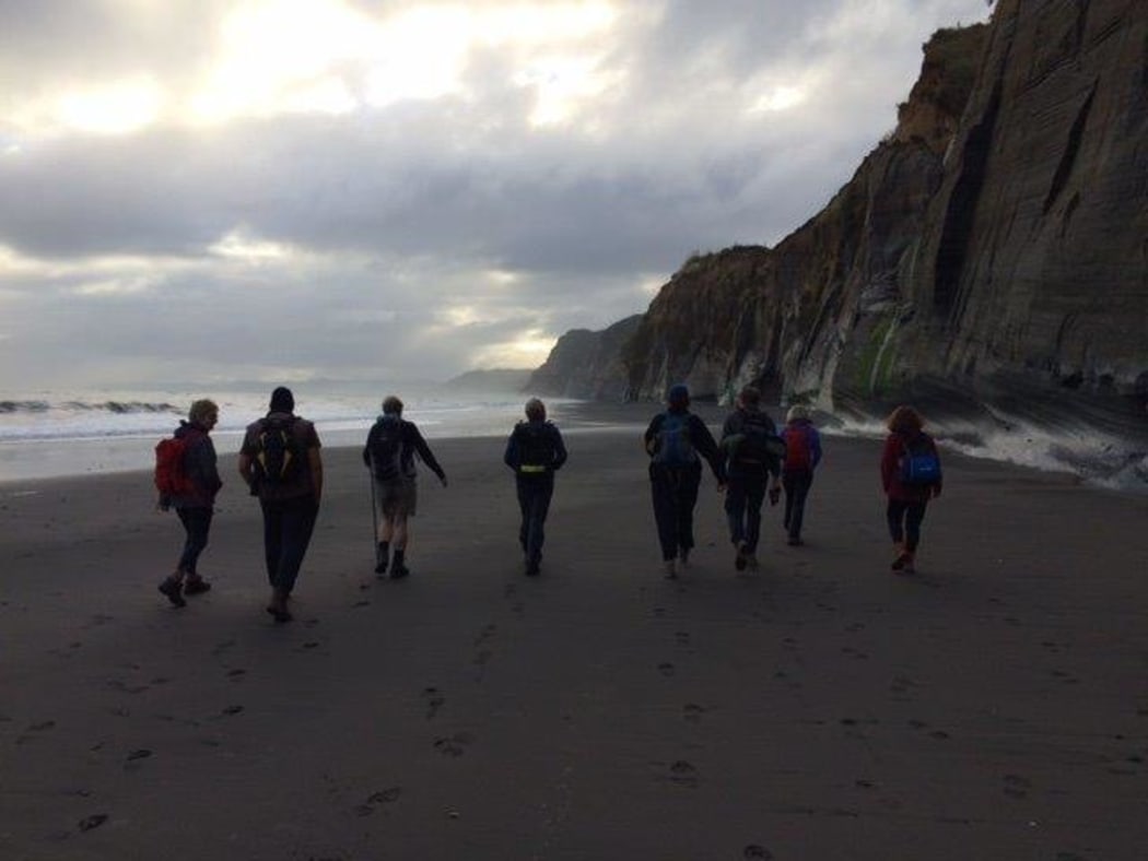 Trampers on a beach section of the Whitecliffs walkway