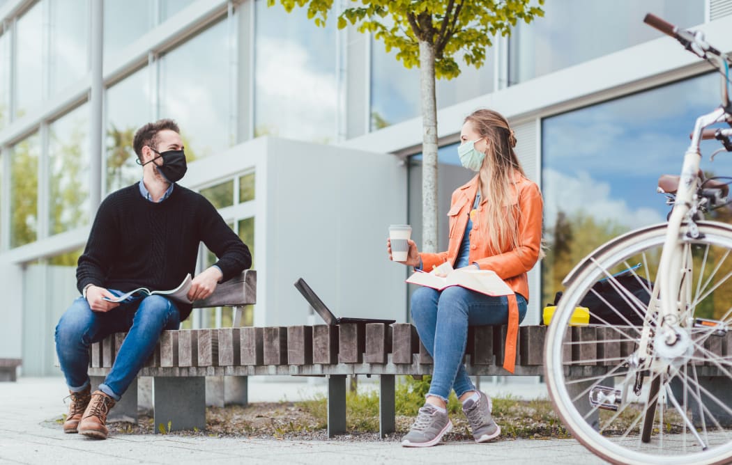 Students on university campus keeping social distance and wearing face masks due to coronavirus