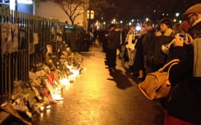 People are laying flowers outside the Charlie Hebdo offices.