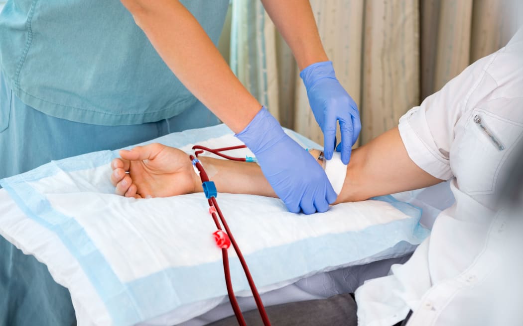 Nurse in renal unit at hospital starting dialysis on patient