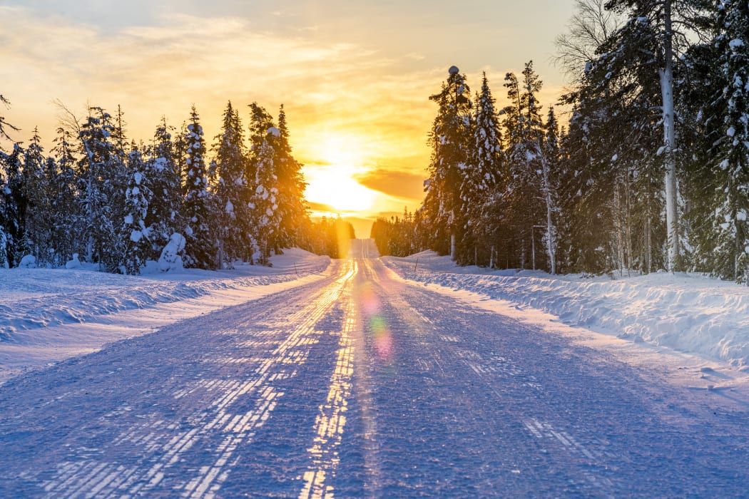 Sunset over an empty snowy road, Lapland, Finland, Europe (Photo by Roberto Moiola / Robert Harding RF / robertharding via AFP)
