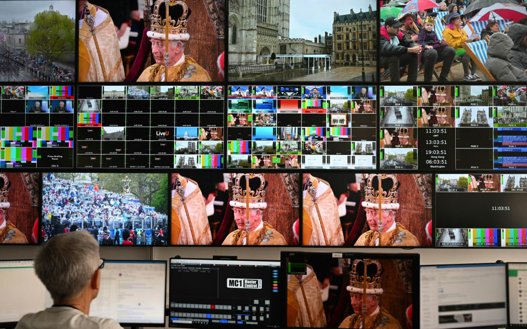 This photograph taken on May 6, 2023, in a newsroom in Paris shows screens broadcasting the televised coronation ceremony of Britain's King Charles III. (Photo by Emmanuel DUNAND / AFP)