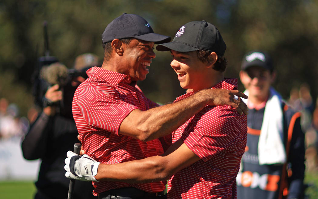 ORLANDO, FLORIDA - DECEMBER 22: Tiger Woods of the United States reacts with his son Charlie Woods after making the first hole-in-one of his career on the fourth hole during the second round of the PNC Championship at Ritz-Carlton Golf Club on December 22, 2024 in Orlando, Florida.   Mike Ehrmann/Getty Images/AFP (Photo by Mike Ehrmann / GETTY IMAGES NORTH AMERICA / Getty Images via AFP)