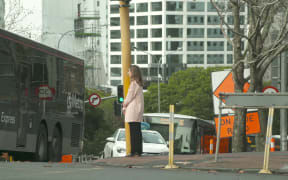 RNZ reporter Louise Ternouth crosses the road in Auckland's CBD.