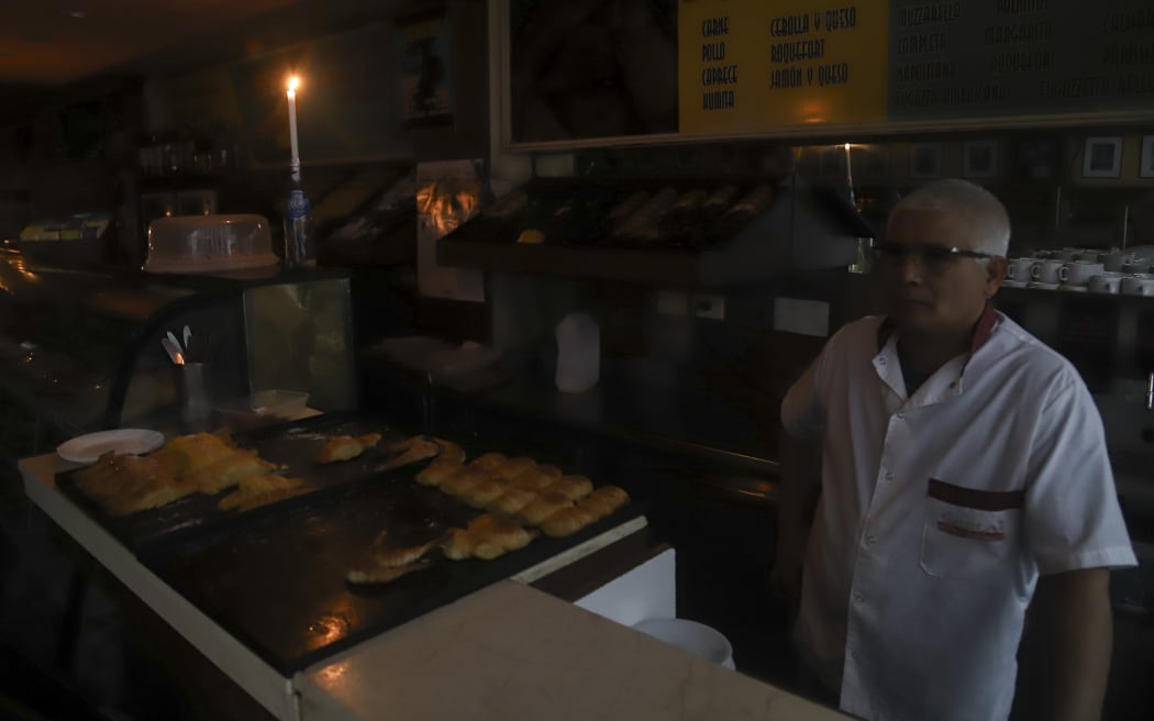 A man working by candlelight in a Buenos Aires bakery during a country-wide power cut on 16 June 2019.