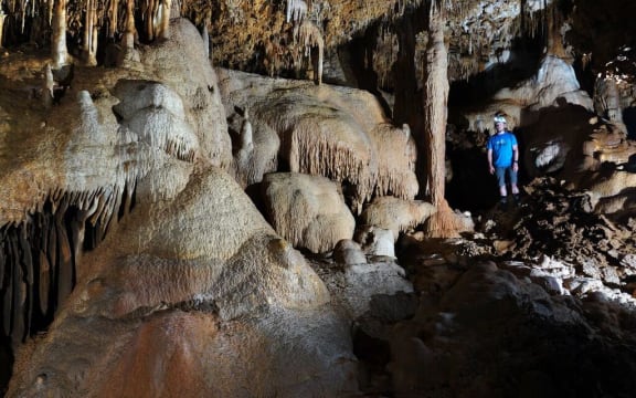 Adam Hartland in a cave filled with speleothems such as stalactites, stalagmites and flowstones, all of which hold records of past climate.
