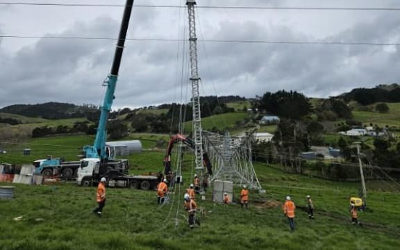 Workers setting up a temporary pylon to supply power to Northland.