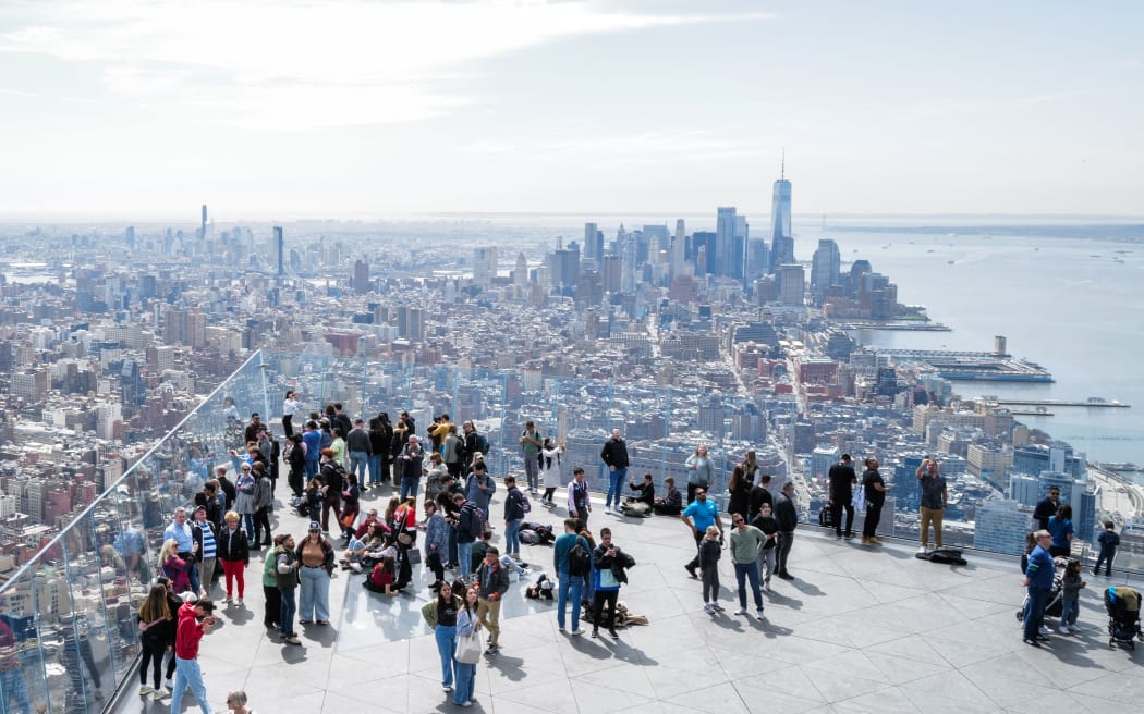 People gather on the 'Edge at Hudson Yards' observation deck ahead of a total solar eclipse across North America, in New York City on April 8, 2024. This year's path of totality is 115 miles (185 kilometers) wide and home to nearly 32 million Americans, with an additional 150 million living less than 200 miles from the strip. The next total solar eclipse that can be seen from a large part of North America won't come around until 2044. (Photo by CHARLY TRIBALLEAU / AFP)