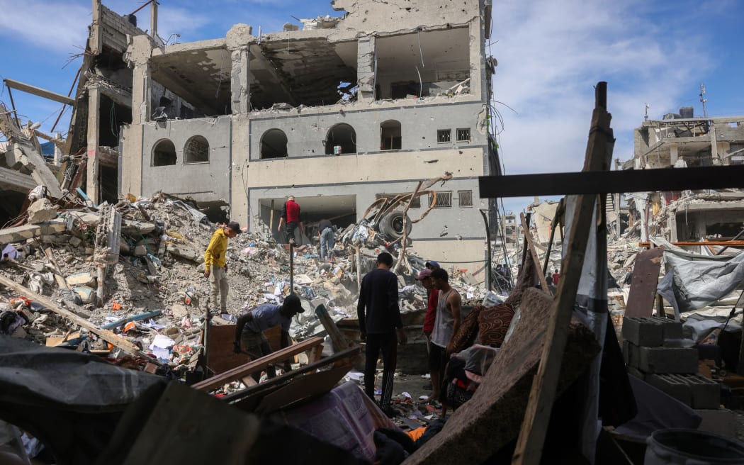 People look for salvageable items in the rubble of a building hit in an Israeli strike in Jabalia in the northern Gaza Strip on May 15, 2025. Fighting has raged in Gaza, where civil defence officials told AFP 80 people were killed by Israeli bombardment on May 14, including 59 in the north. (Photo by BASHAR TALEB / AFP)