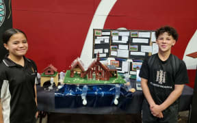 Meremia and Ezra from Te Rangihakahaka Wakanoa and their model of a marae built to rise from floodwaters
